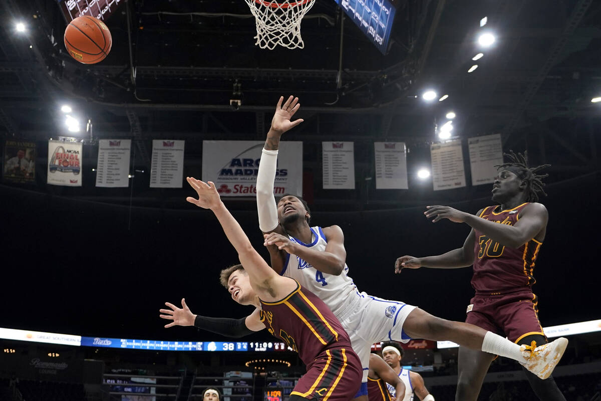 Drake's ShanQuan Hemphill, center, loses control of the ball as Loyola of Chicago's Braden Norr ...