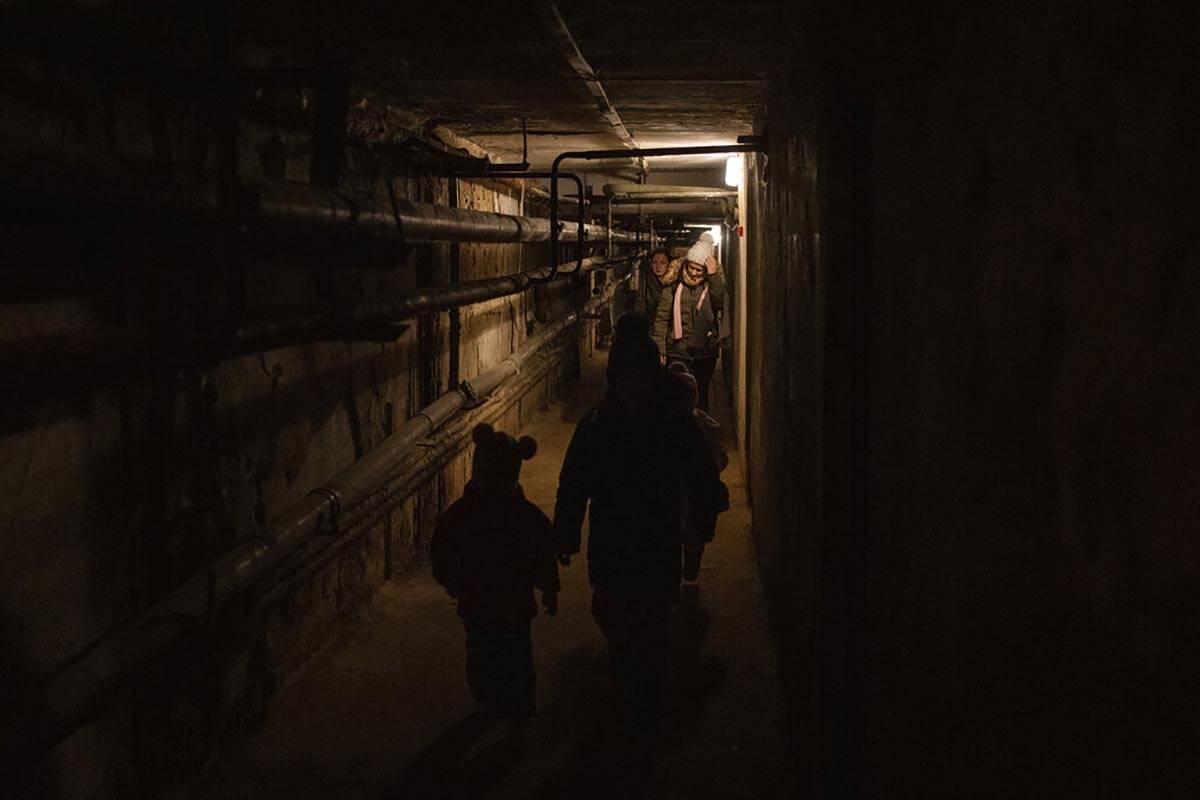 A family walks out of a basement used as shelter during an air-raid alarm in Novoiavorisk, west ...