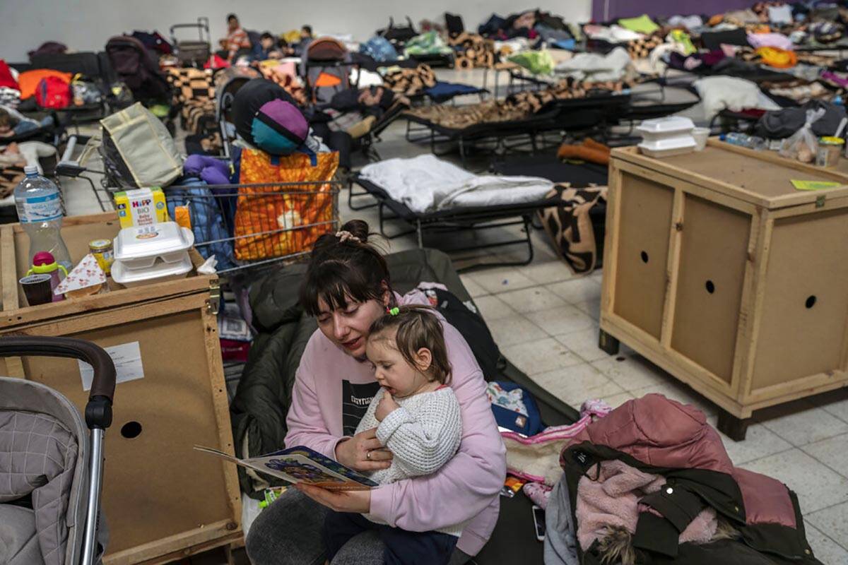 Kate who fled Ukraine reads a story to her 16 month daughter Dianna in a refugee center in Korc ...