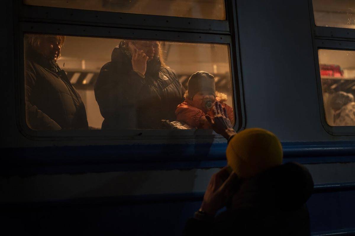 Displaced Ukrainians on a Poland bound train bid farewell in Lviv, western Ukraine, Sunday, Mar ...