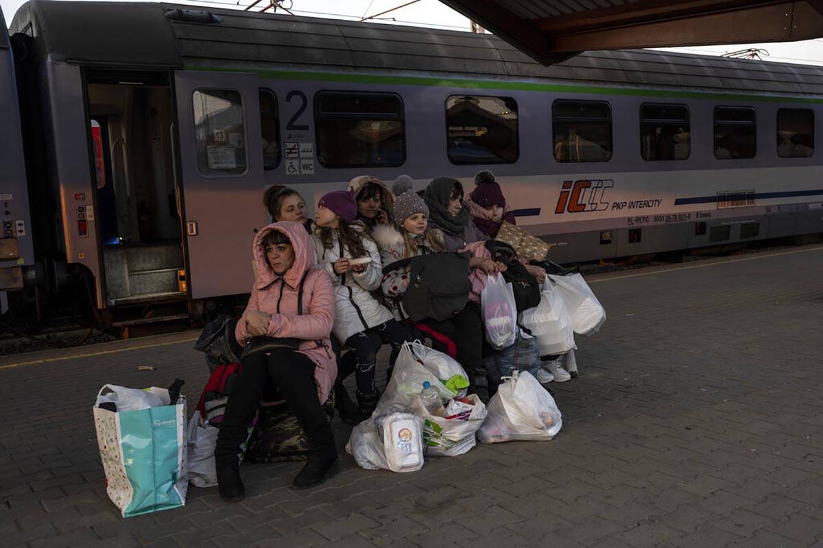 A Ukrainian family who fled the war waits at the train station in Przemysl, southeastern Poland ...