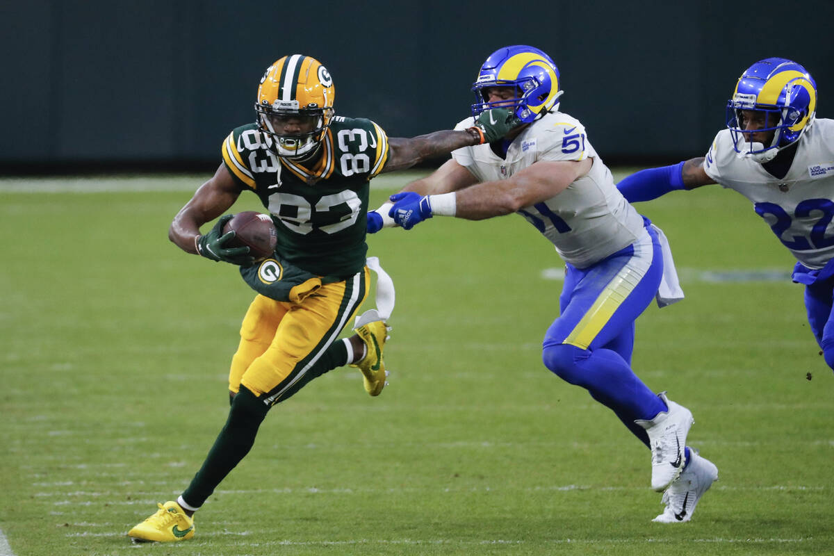 Green Bay Packers' Marquez Valdes-Scantling (83) pushes off Los Angeles Rams' Troy Reeder (51) ...