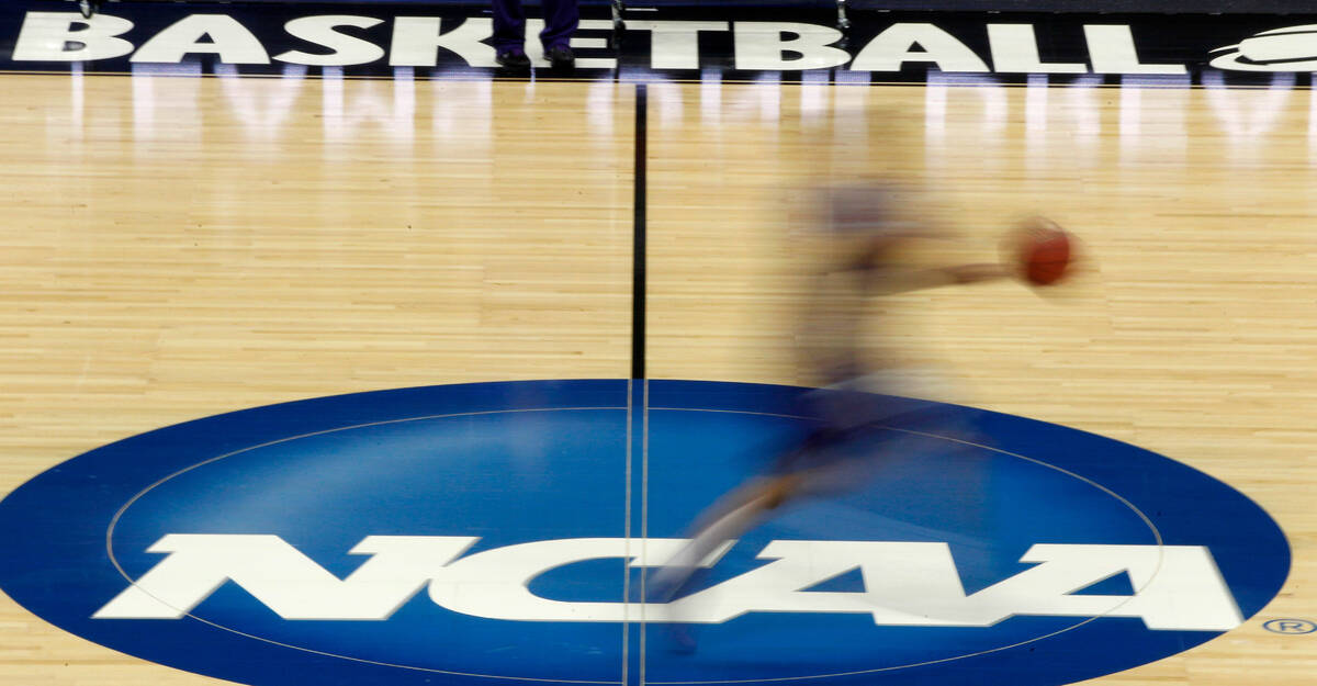 In this file photo, a player runs across the NCAA logo during practice in Pittsburgh before an ...