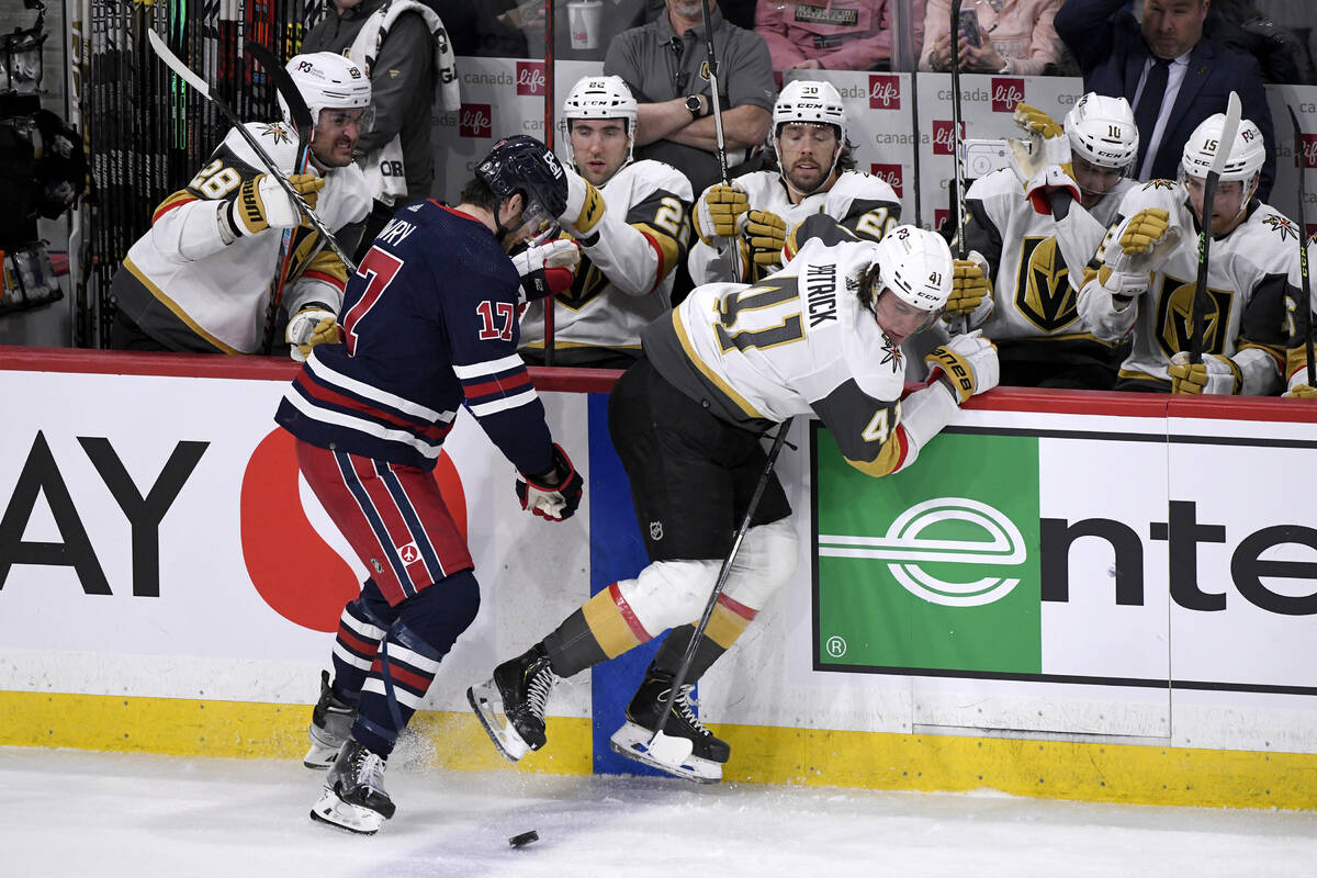 Winnipeg Jets' Adam Lowry (17) checks Vegas Golden Knights' Nolan Patrick (41) in front of the ...