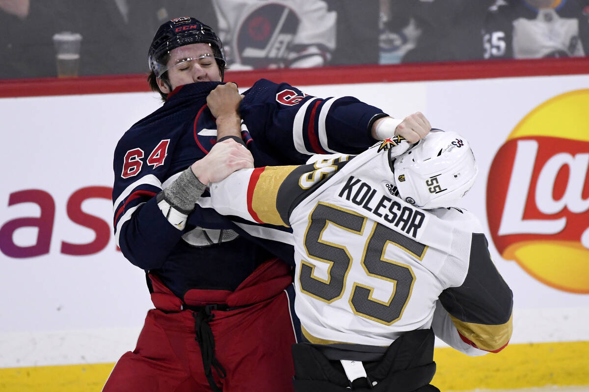 Winnipeg Jets' Logan Stanley (64) fights with Vegas Golden Knights' Keegan Kolesar (55) during ...