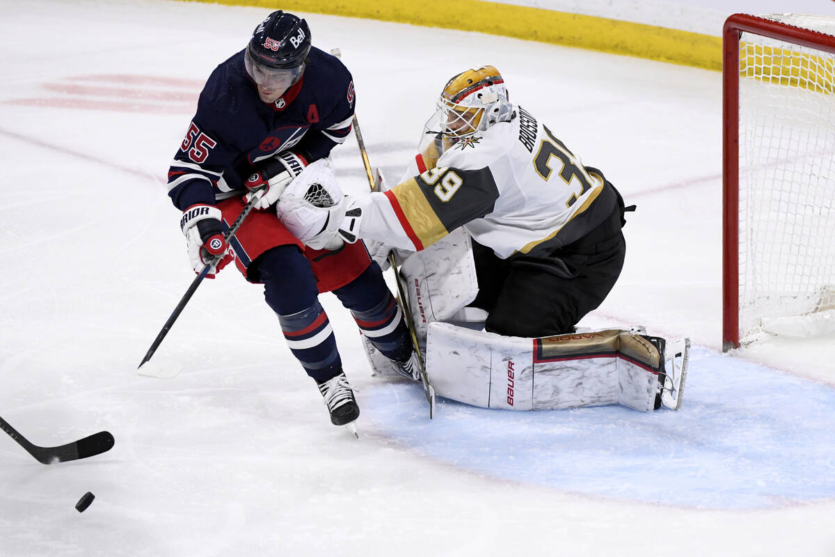 Winnipeg Jets' Mark Scheifele (55) looks to get control of the puck as Vegas Golden Knights goa ...