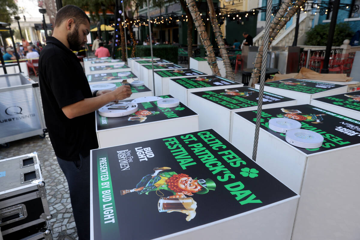 Kian Jarey sets up tables Wednesday, March 16, 2022, on the Brooklyn Bridge at New York-New Yor ...