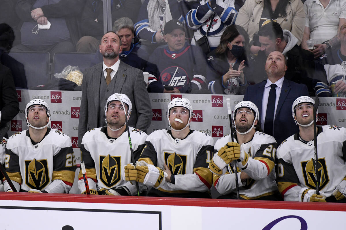 Vegas Golden Knights coach Pete DeBoer, left, and players look up to view a replay of a Winnipe ...