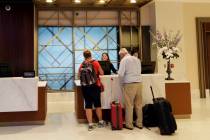 Guests stand at the front desk at the Embassy Suites by Hilton hotel in Seattle's Pioneer Squar ...