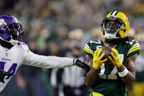 Green Bay Packers' Davante Adams catches a pass in front of Minnesota Vikings' Mackensie Alexan ...