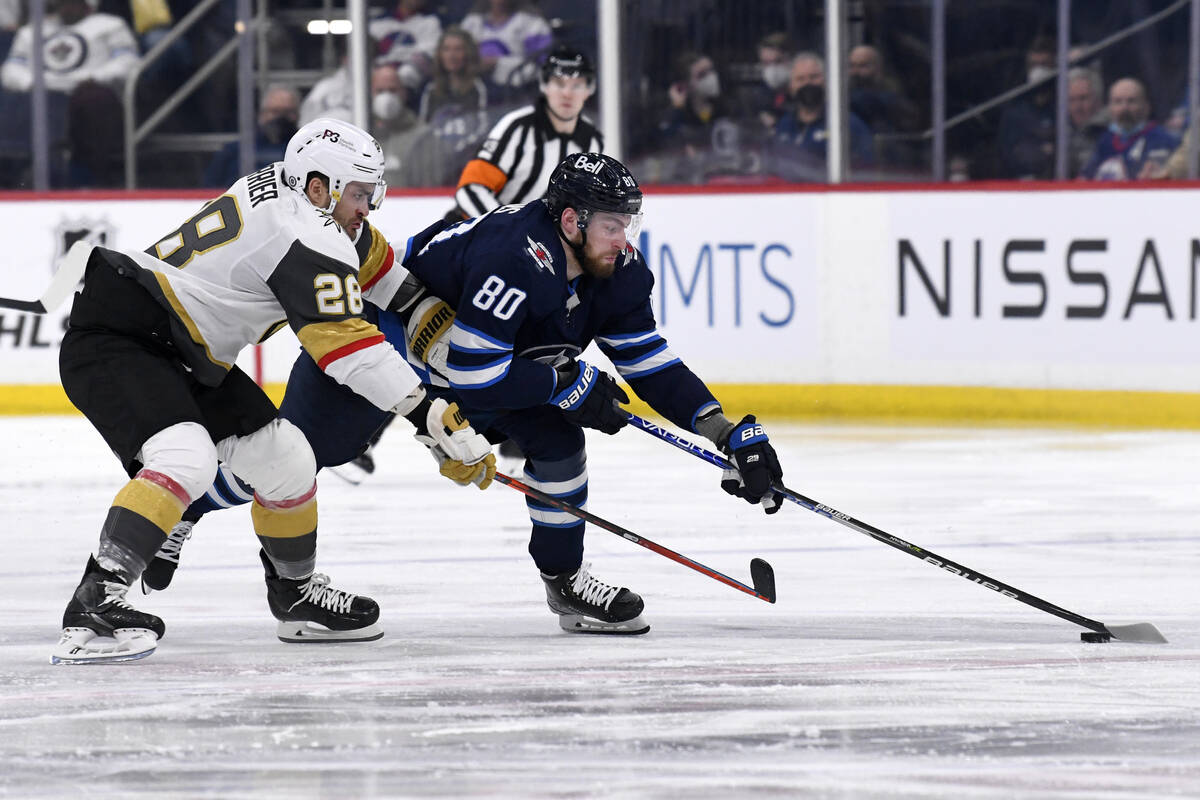 Winnipeg Jets' Pierre-Luc Dubois (80) skates with the puck around Vegas Golden Knights' William ...