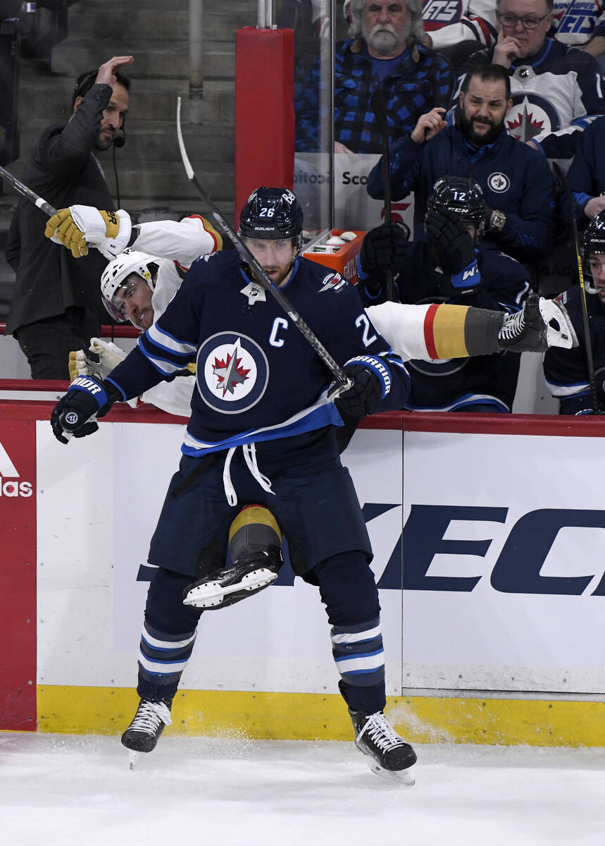 Winnipeg Jets' Blake Wheeler (26) checks Vegas Golden Knights' Nicholas Roy (10) into the board ...