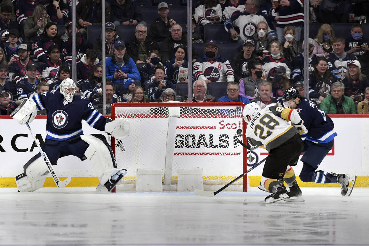 Vegas Golden Knights' William Carrier's (28) shot goes wide as Winnipeg Jets goaltender Connor ...