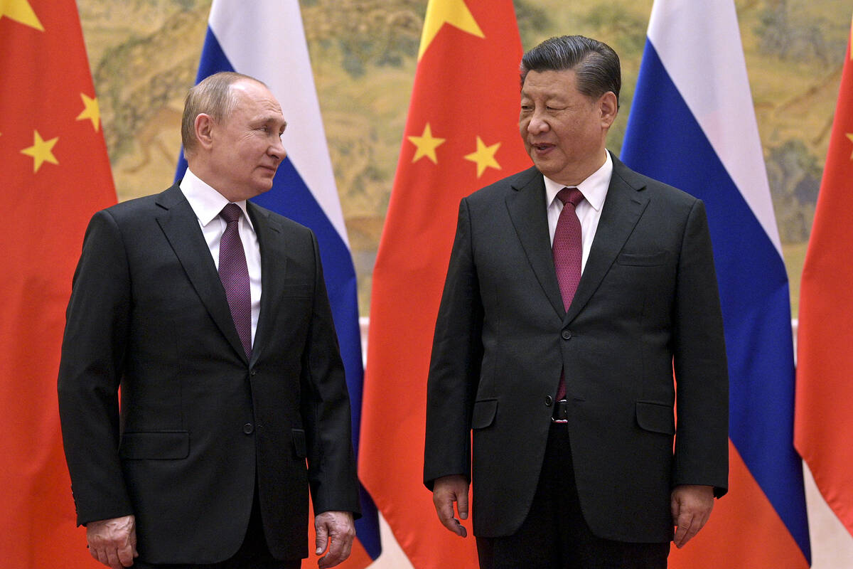 FILE - Chinese President Xi Jinping, right, and Russian President Vladimir Putin talk to each o ...