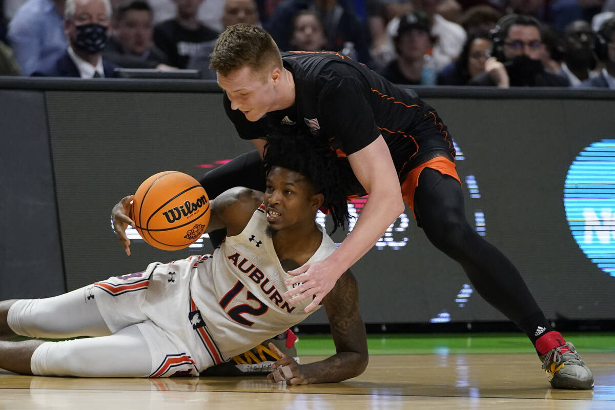 Auburn guard Zep Jasper (12) vies for a loose ball with Miami forward Sam Waardenburg during th ...