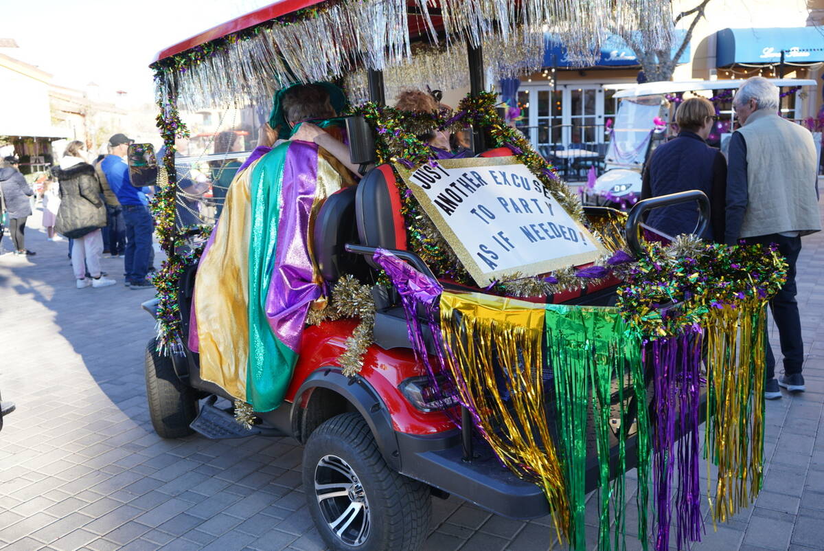 Parade-goers gathered in The Village along the lake to show off their Mardi Gras colorful outfi ...