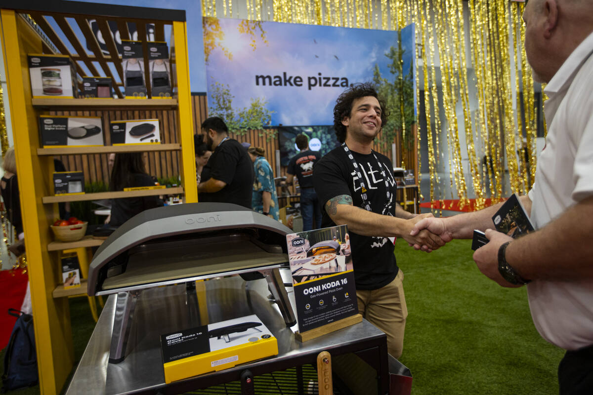 Zach Miller, of Ooni Pizza Ovens, greets an attendee during the International Pizza Expo at the ...