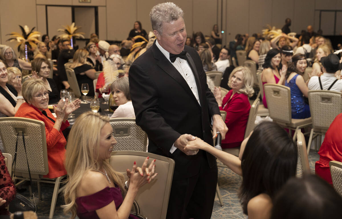 Auctioneer Christian Kolberg, middle, congratulates a winning bidder during the 19th annual Jun ...