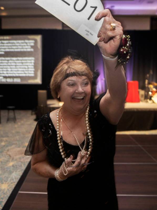 Lifetime Community Achievement Award honoree Judy Beal celebrates a winning bid during the 19th ...