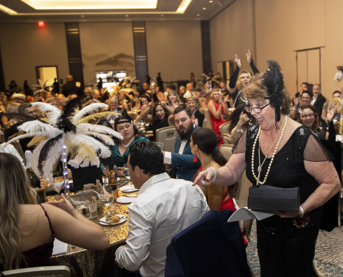 Lifetime Community Achievement Award honoree Judy Beal, right, walks toward the stage during th ...