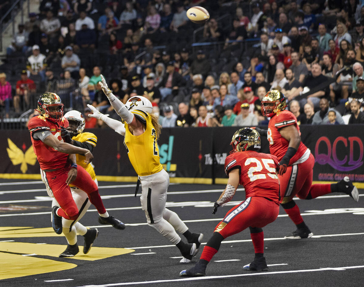 Vegas Knight Hawks quarterback Jaylon Henderson (9) makes a leaping throw over Tucson Sugar Sku ...