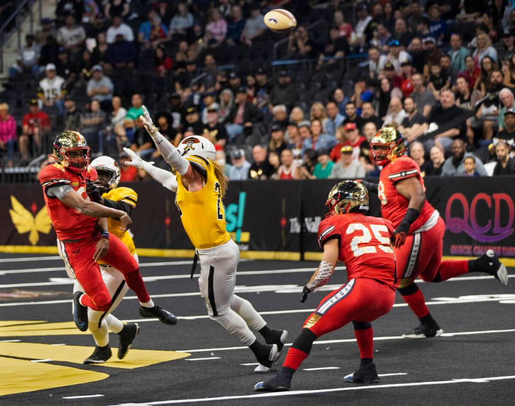 Vegas Knight Hawks quarterback Jaylon Henderson (9) makes a leaping throw over Tucson Sugar Sku ...