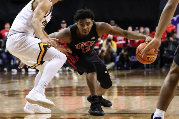 UNLV Rebels guard Bryce Hamilton (13) drives the ball against Wyoming Cowboys guard Brendan Wen ...