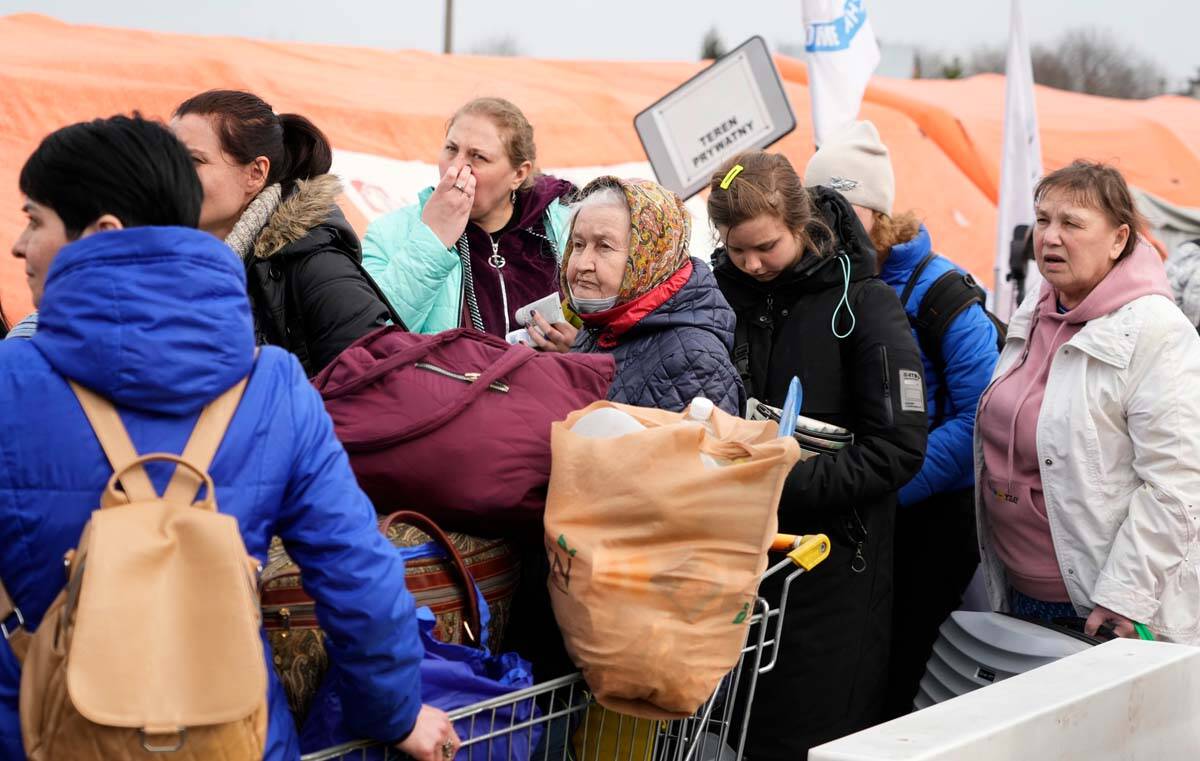 Refugees stand in a queue with their belongings after fleeing the war from neighbouring Ukraine ...