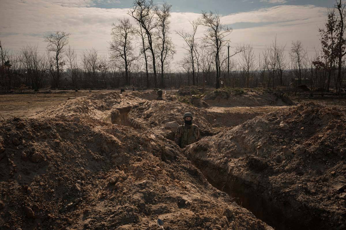 Ukrainian servicemen stand in trenches at a position north of the capital Kyiv, Ukraine, Tuesda ...