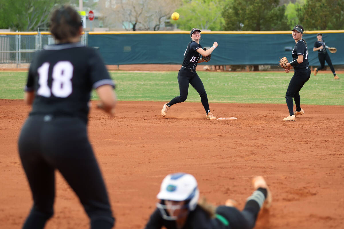 Faith Lutheran’s Savannah Moore (15) throws a late ball to Ava Mariani (18) at first ba ...