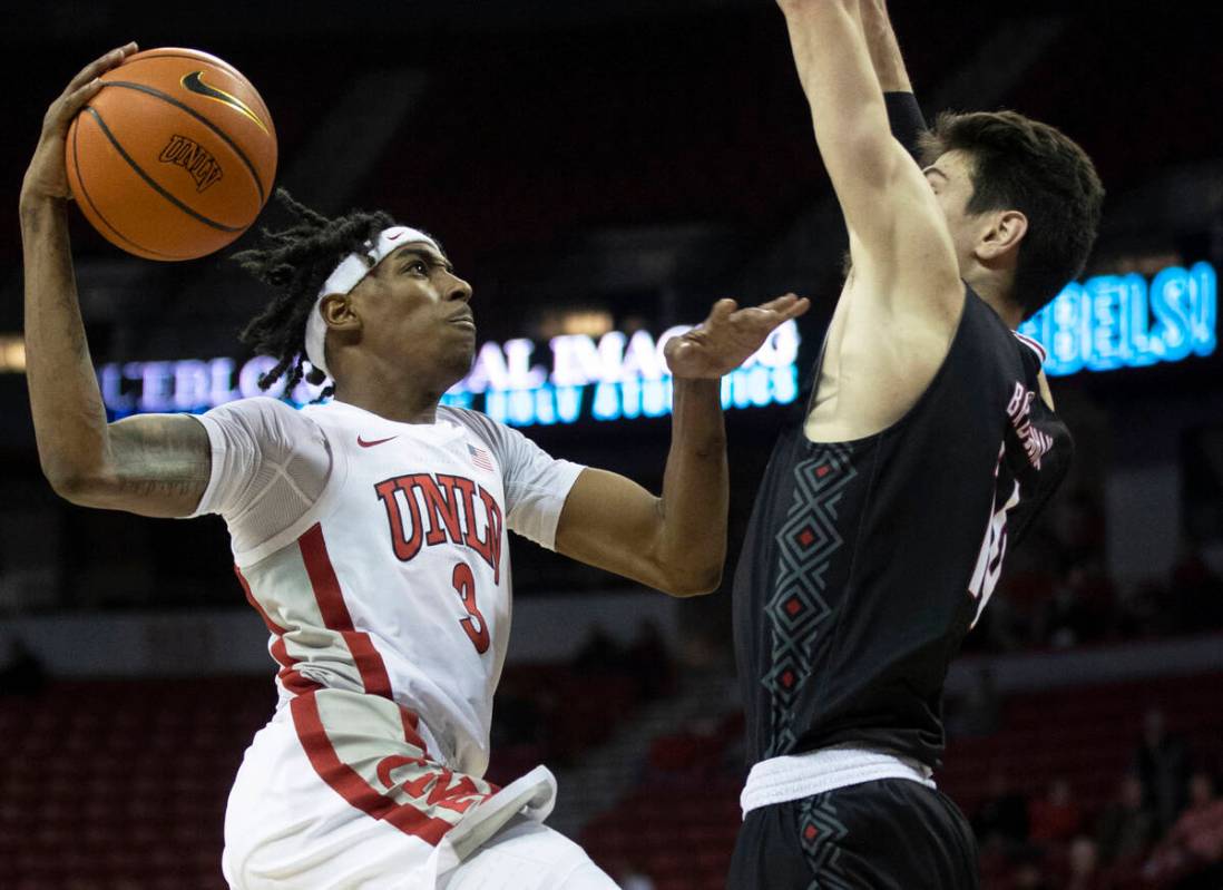 UNLV Rebels forward Donovan Williams (3) drives past Omaha Mavericks center Dylan Brougham (14) ...