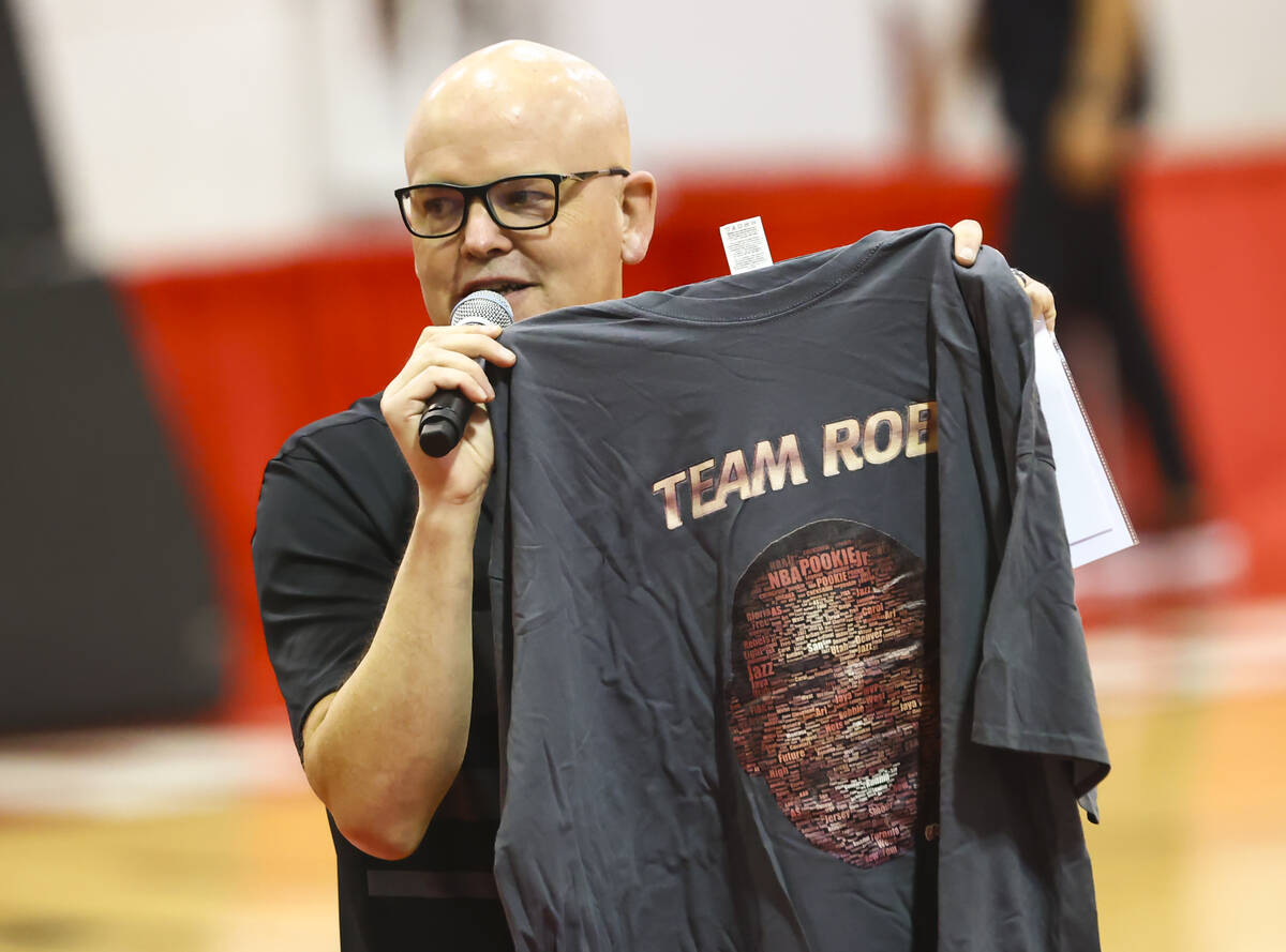 Host Chet Buchanan holds up a shirt featuring former player Robert Smith during an open UNLV ba ...