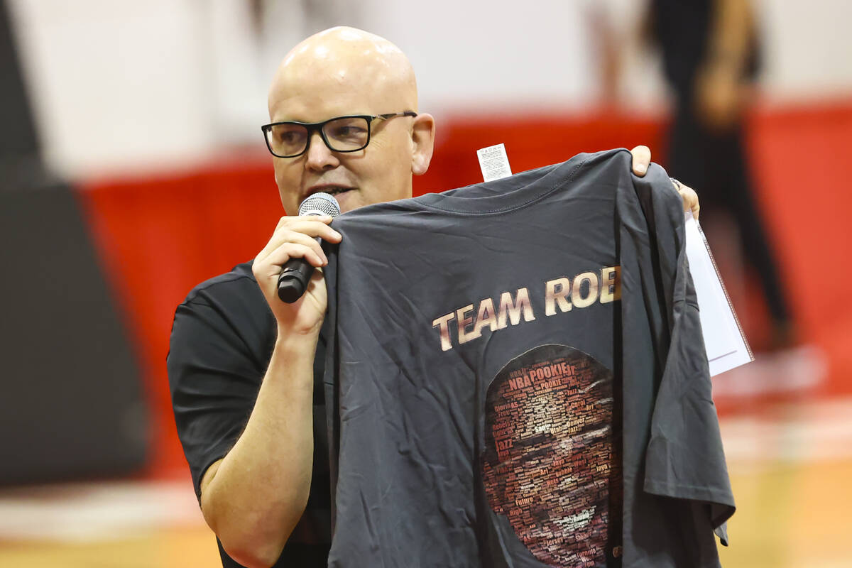 Host Chet Buchanan holds up a shirt featuring former player Robert Smith during an open UNLV ba ...