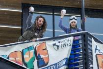 Justin Randall and Caroline Bye, both of Las Vegas, toss snowballs down towards a friend while ...