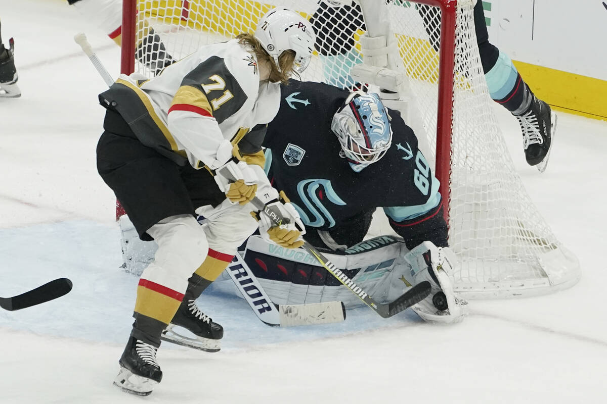 Seattle Kraken goaltender Chris Driedger (60) stops a shot by Vegas Golden Knights center Willi ...