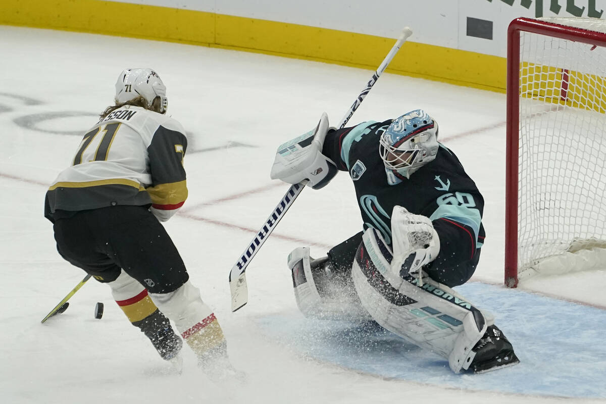 Seattle Kraken goaltender Chris Driedger (60) stops a shot by Vegas Golden Knights center Willi ...