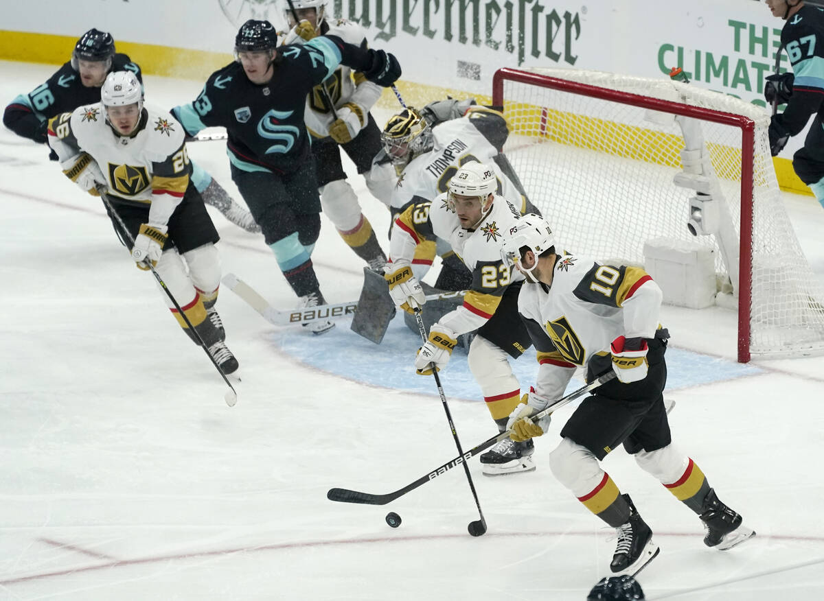 Vegas Golden Knights defenseman Alec Martinez (23) and center Nicolas Roy (10) work to clear th ...