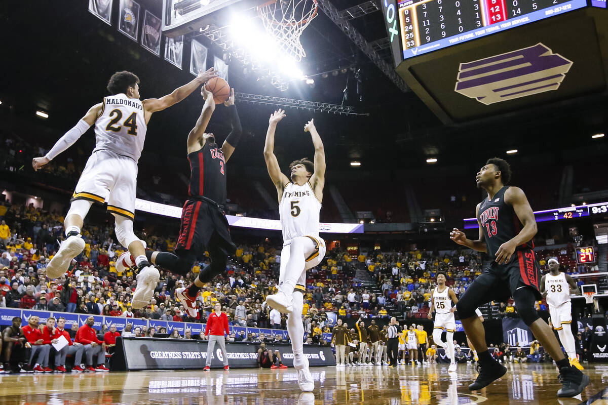 UNLV Rebels guard Justin Webster (2) attempts a layup between Wyoming Cowboys guards Hunter Mal ...