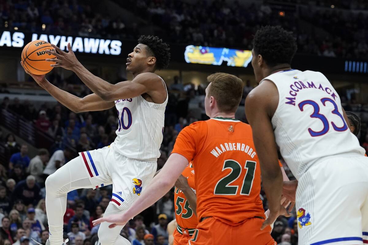 Kansas' Ochai Agbaji shoots during the second half of a college basketball game in the Elite 8 ...