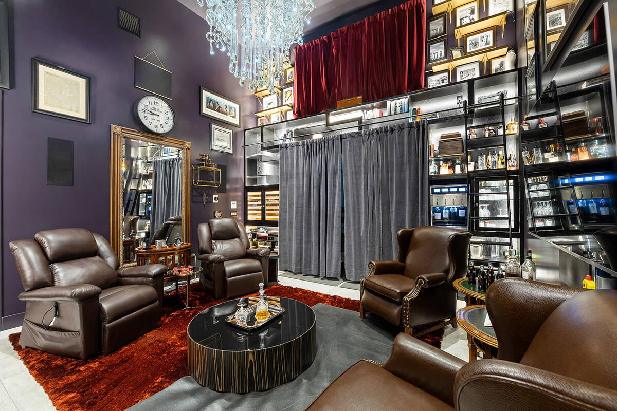 Dividing the two garages is a comfortable hideaway filled with plush brown leather chairs, fire ...