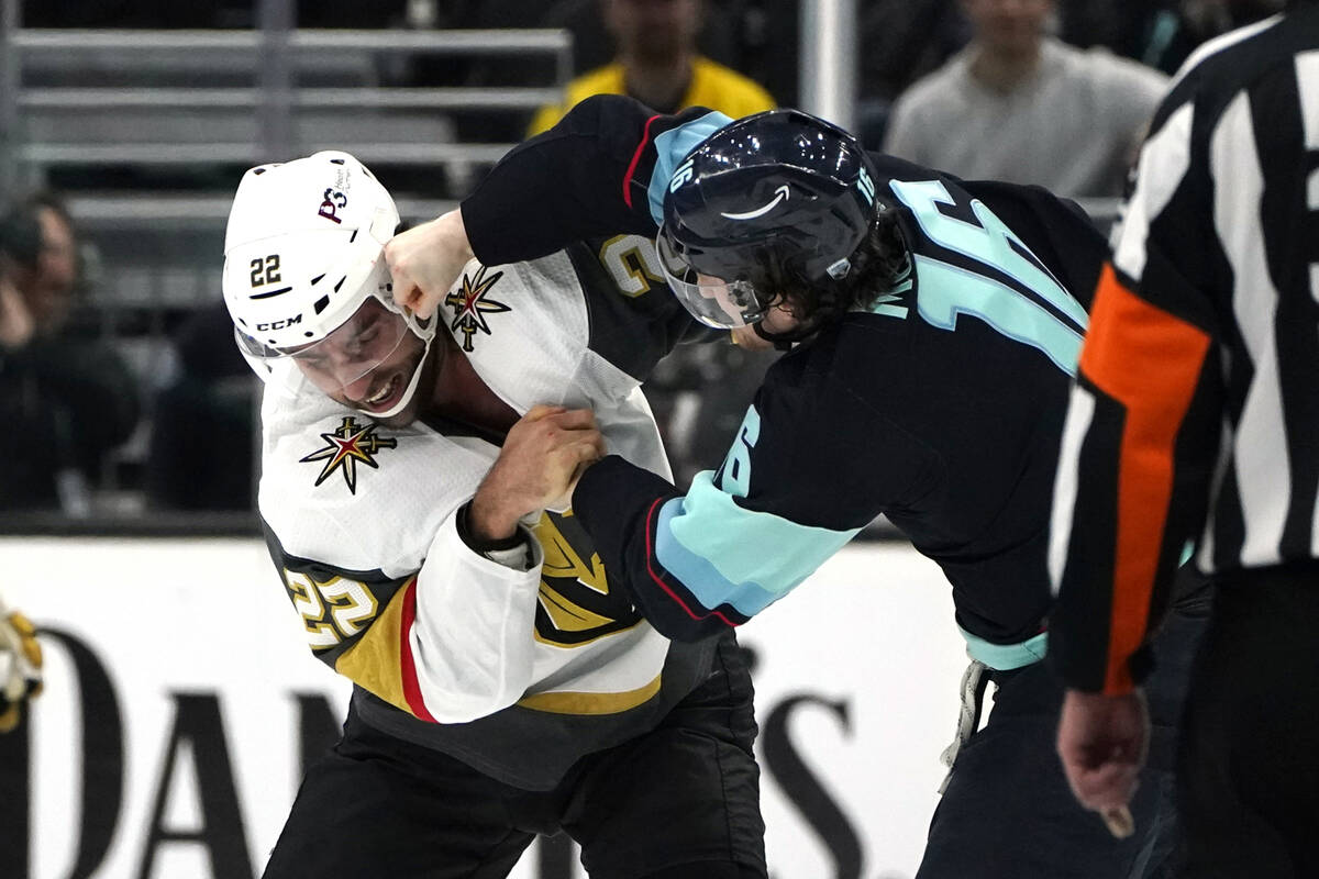 Seattle Kraken's Jared McCann, right, takes a swing at Vegas Golden Knights' Michael Amadio as ...