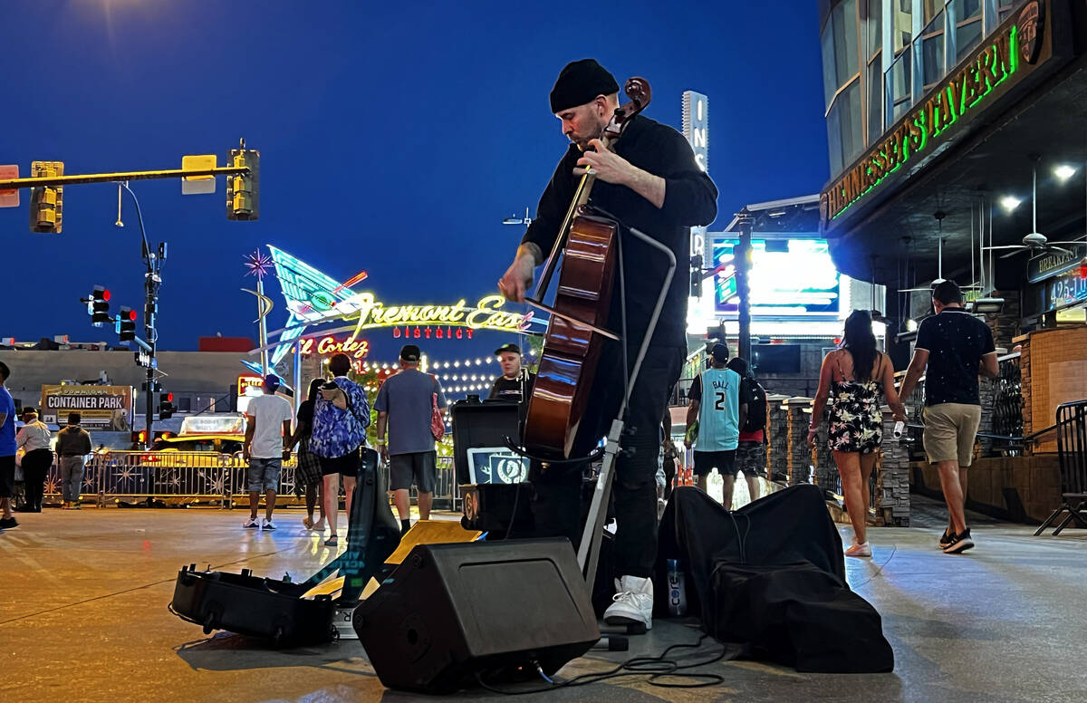 Street performer Jordan Polovina with the group Grim & Darling plays and electric cello wit ...