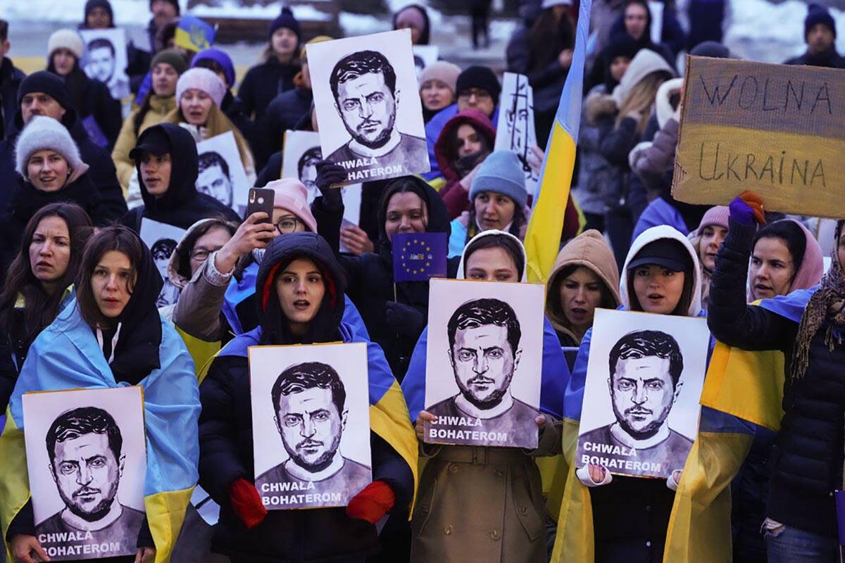 People hold portraits of Ukrainian President Volodymyr Zelenskyy during an anti-war rally in fr ...