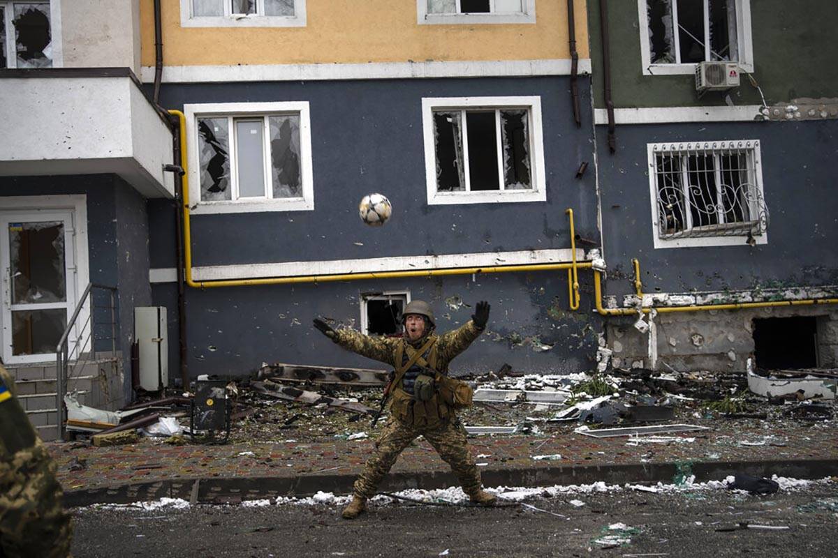 A Ukranian soldier eyes a soccer ball during a pick-up game in Irpin, on the outskirts of Kyiv, ...