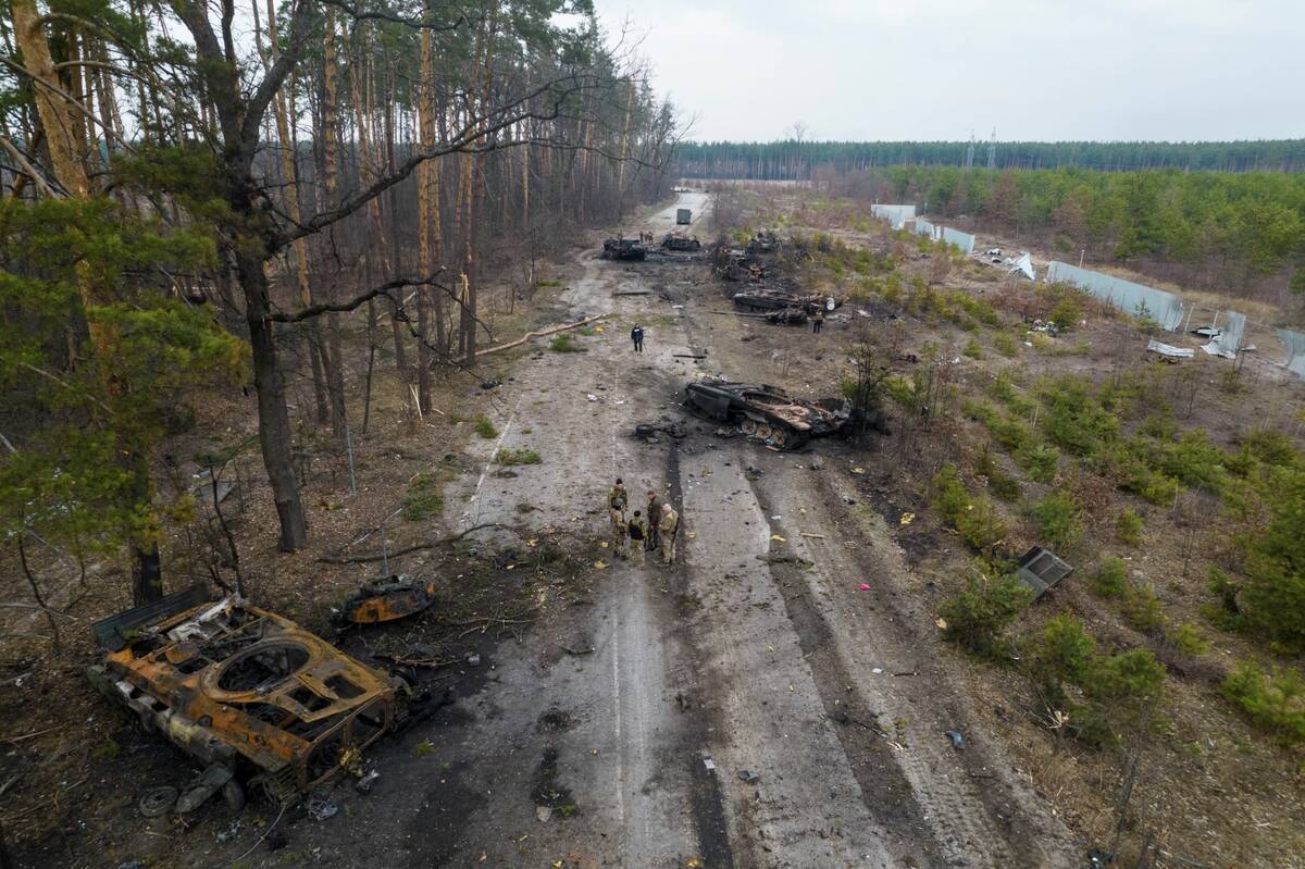 Ukrainian soldiers stand amid destroyed Russian armor vehicles in the outskirts of Kyiv, Ukrain ...