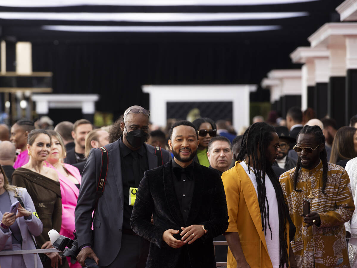 John Legend, middle, on the red carpet before the start of the 2022 Grammy Awards on Sunday, Ap ...