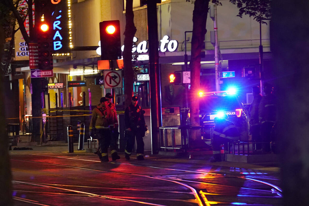Emergency personnel walk near the scene of an apparent mass shooting in Sacramento, Calif., Sun ...