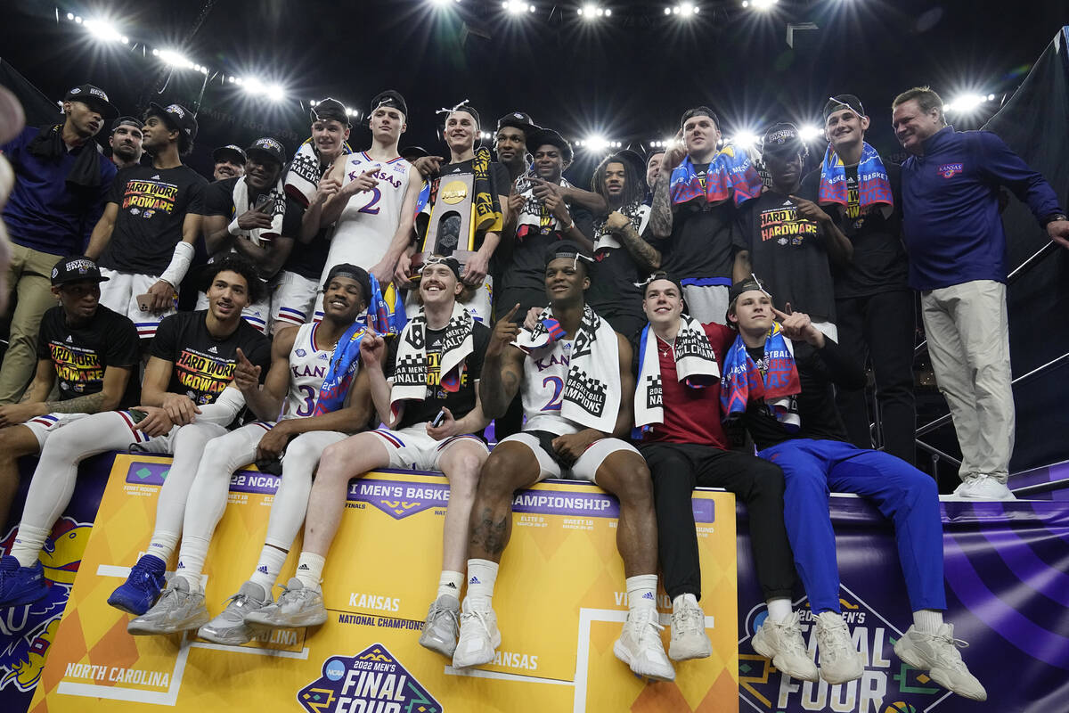 Kansas players pose with the trophy after defeating North Carolina in a college basketball game ...