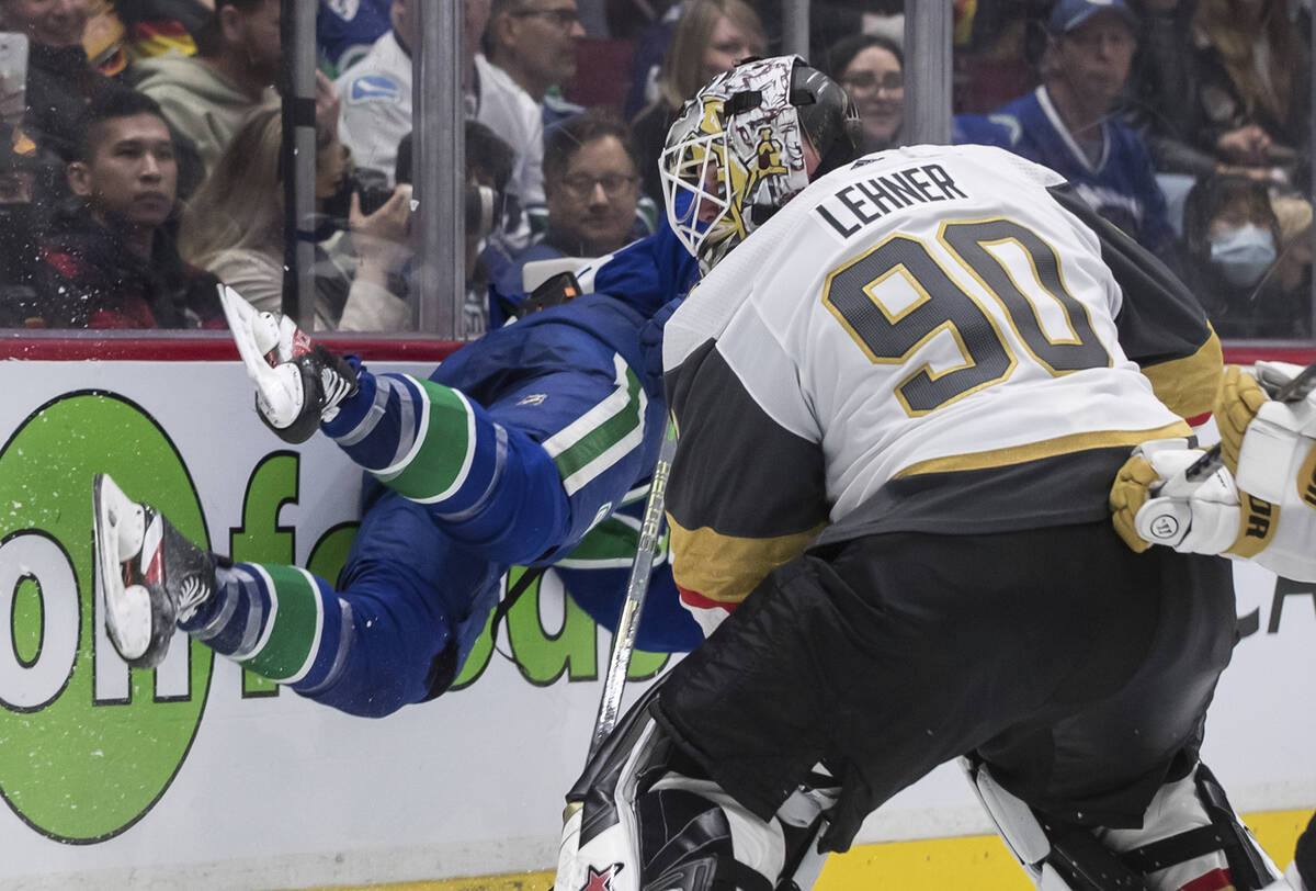 Vegas Golden Knights goalie Robin Lehner trips Vancouver Canucks' Jason Dickinson, back, during ...