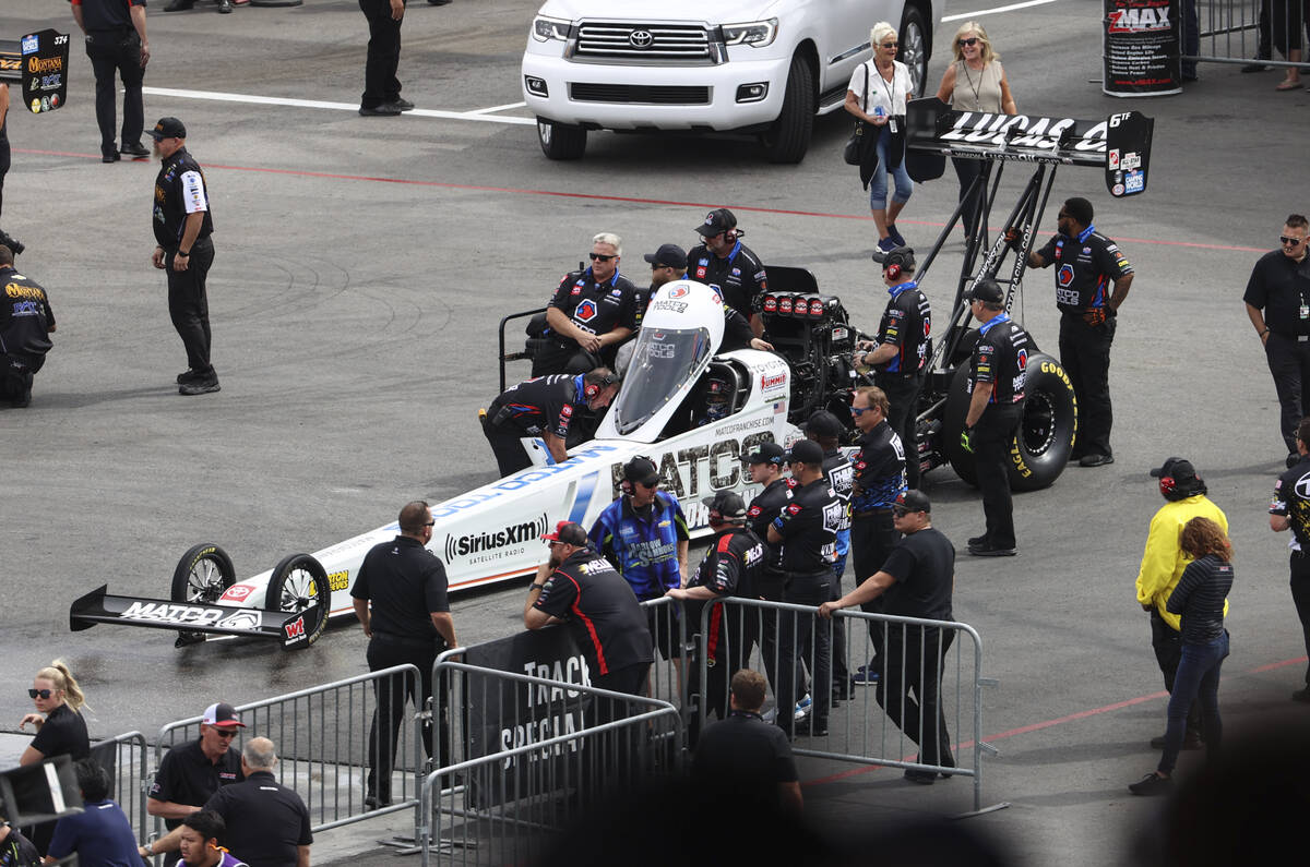 Crew members of Top Fuel driver Antron Brown prepare for the second round of Top Fuel eliminati ...